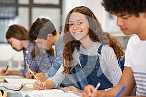 Portrait of happy high school girl studying in class