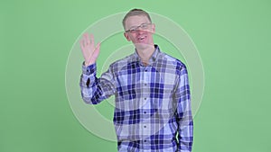 Portrait of happy hipster man waving hand