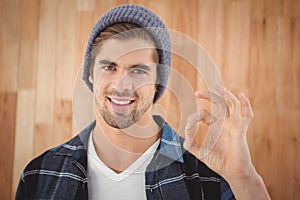 Portrait of happy hipster showing OK sign