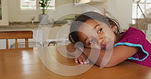 Portrait of happy hispanic girl relaxing lying on table