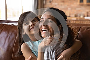 Portrait of happy Hispanic mom and daughter hugging