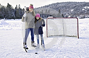 portrait of happy hockey girl player with his mother on a lake