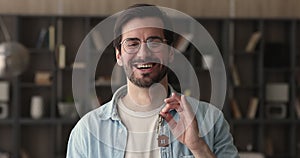 Portrait of happy homeowner showing keys from new bought house