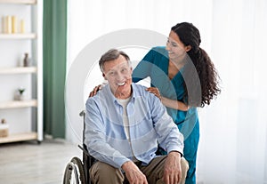 Portrait of happy impaired elderly man and his female nurse at retirement home. Professional medical care for seniors