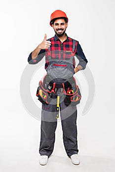 Portrait of happy indian handyman with tools showing thumbs up sign isolated on white background