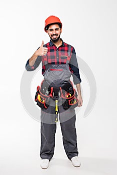 Portrait of happy indian handyman with tools showing thumbs up sign isolated on white background