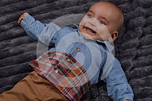 Portrait of a happy infant baby boy in denim blue shirt