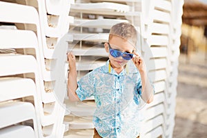 Portrait of happy joyful beautiful little boy wearing blue mirror sunglasses.