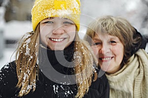 Portrait of happy joyful family grandmother and granddaughter enjoying winter walk together