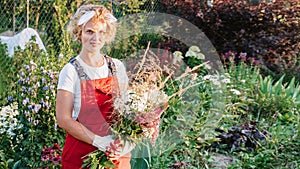 Portrait of a happy, joyful woman-florist-gardener with a bouquet in the open air. A place for your text. Gardening and