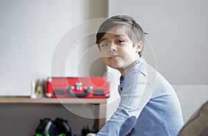 Portrait happy kid playing alone in living room, New normal life stlye Child relaxing at home on weekend. cute boy looking at