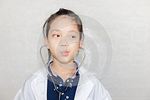 Portrait of Happy kid playing dream careers, Cheerful child in doctor coat with stethoscope blurred background