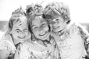 Portrait of happy kids in colored powder holi. Kids face painted in the colors of Holi festival. Holi paint party.
