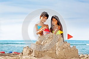 Kids having fun building sandcastle on the beach