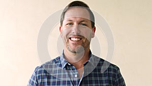 Portrait of happy laughing business man looking joyful inside a bright room. Closeup face of cheerful male entrepreneur