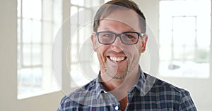 Portrait of happy laughing business man looking joyful inside a bright room with copy space. Closeup of male