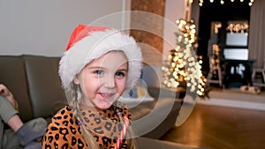 Portrait of happy laughing girl with lollipop christmas at home