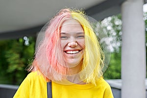 Portrait of a happy laughing teenage girl with colored dyed hair