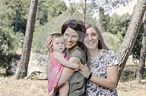 Portrait of happy lesbians mothers with a baby. Homosexual fami