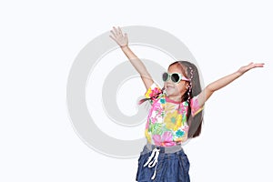 Portrait of happy little Asian kid girl stretch arms wide open up wearing a floral pattern summer dress and sunglasses isolated on