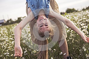 Portrait of Happy little blond girl playing upside down