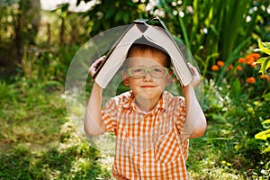 Portrait Happy little boy holding a big book on his first day to school or nursery. Outdoors, Back to school concept.