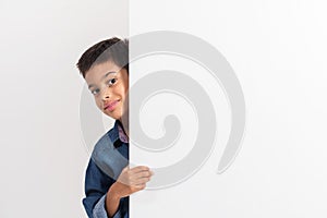 Portrait of a happy little boy holding a blank board against white background