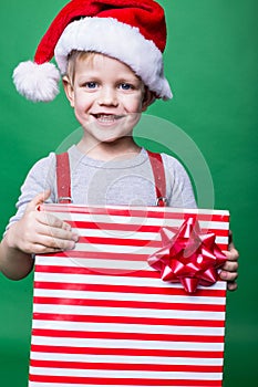 Portrait of a happy little boy holding a new Christmas gift