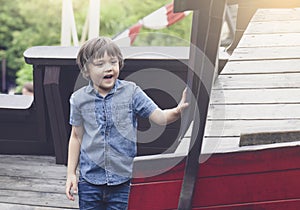 Portrait of happy little boy playing in the playground in the park, Kid with smiling face enjoy playing outdoor, Active child