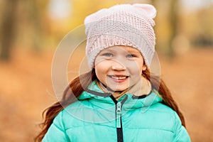 Portrait of happy little girl at autumn park