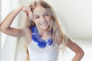 Portrait of a happy little girl model with charming smile posing in a studio.