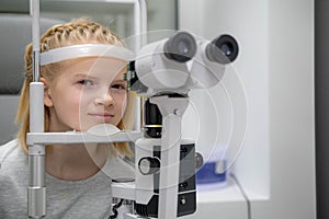 portrait happy little girl patient ophthalmology clinic, vision test in progress cheerful child an optometric