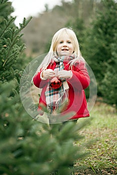 Portrait of happy little girl standing with bauble