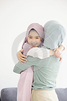 Portrait of happy lovely family arabic muslim mother hug little daughter smiling