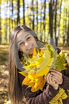 Portrait of happy lovely teenage girl in the forest holding aut