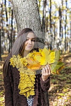 Portrait of happy lovely teenage girl in the forest holding aut