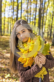 Portrait of happy lovely teenage girl in the forest holding aut