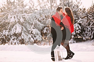 Portrait happy loving couple outdoors hugging and kissing, standing in winter forest park. Love in Valentine`s Day