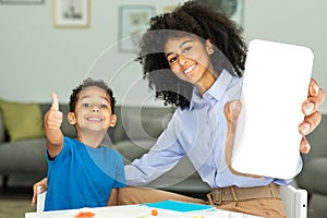 Portrait Of A Happy Loving Family Of Two Mothers And A Male Child Joining Together While Sitting At A Table
