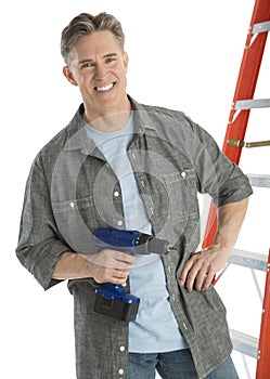 Portrait Of Happy Male Carpenter Holding Drill