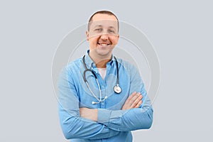 Portrait of a happy male doctor looking at the camera on a light background.