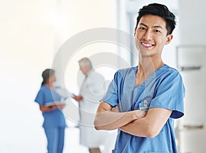 Portrait, happy man and Asian nurse with arms crossed in hospital or clinic. Face, confidence and medical professional