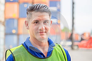 Portrait of happy man at cargo container, Cheerful factory worker smiling and looking at camera with joy, Happiness concept