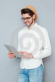 Portrait of a happy man in eyeglasses using tablet computer