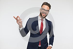 Happy man with glasses laughing and pointing finger to side