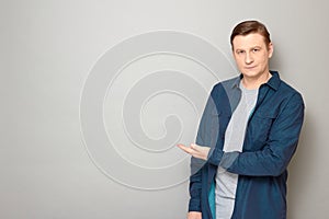 Portrait of happy man pointing with hand at copy space and smiling