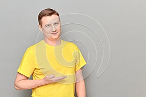 Portrait of happy man pointing with hand at empty place and smiling