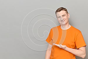 Portrait of happy man pointing with hand at empty place and smiling