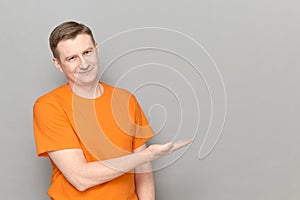 Portrait of happy man pointing with hand at empty place and smiling