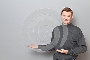 Portrait of happy man pointing with hands at copy space and smiling